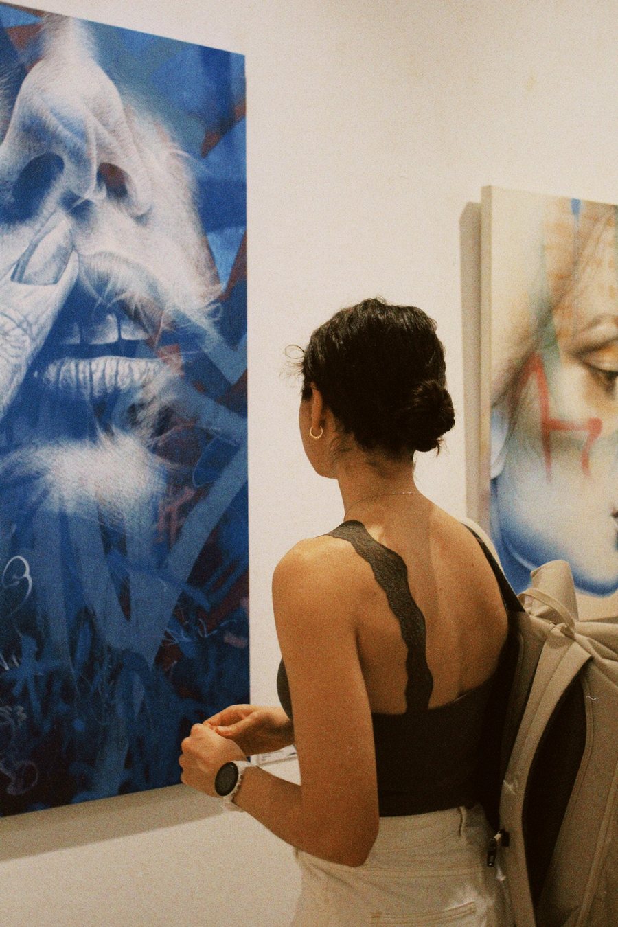 De espaldas, mirando un mural de tonos azules