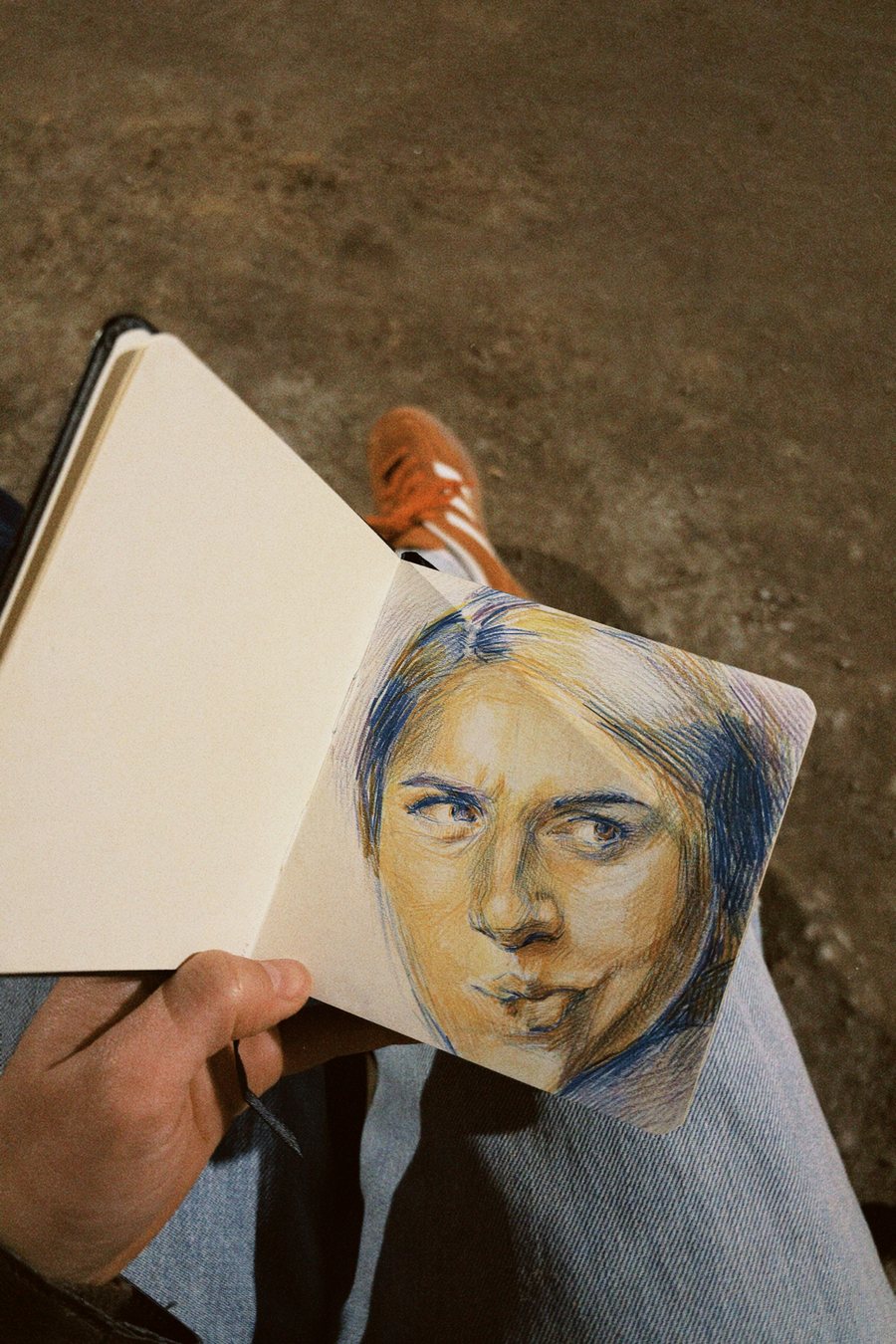 Un cuaderno con un retrato a lápiz, dibujado sobre una roca