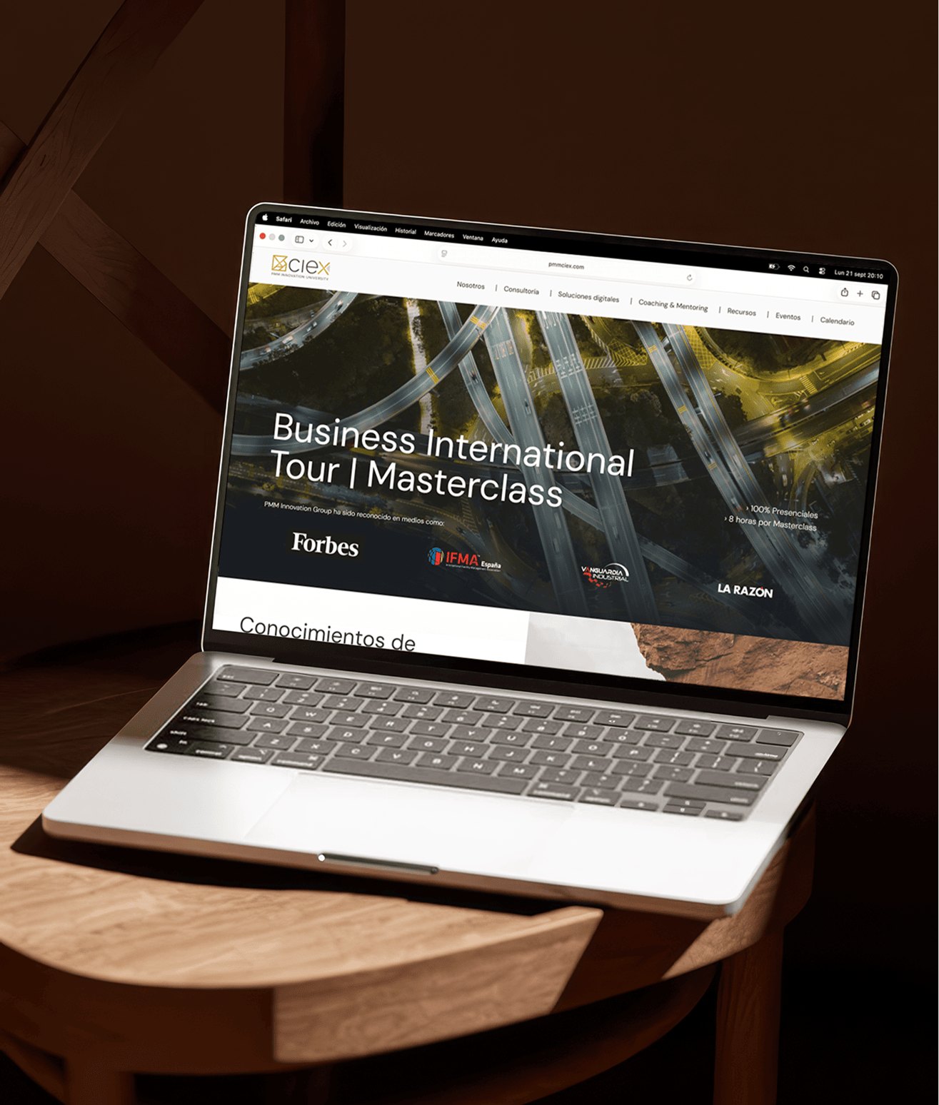 Un portátil con la web de PMM CIEx sobre una mesa de madera